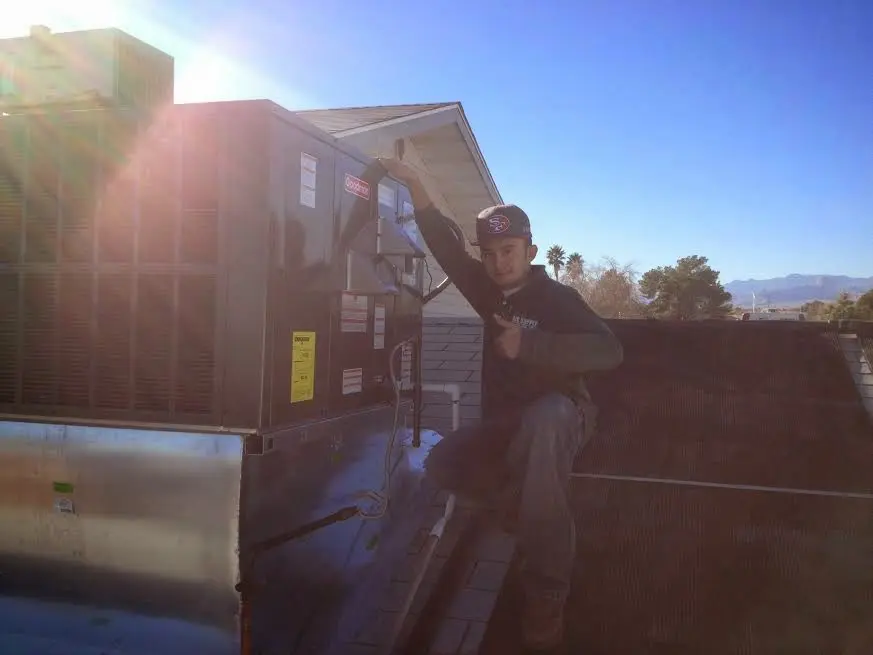 HVAC technician performing AC Tune-Up on a rooftop unit in Somerville